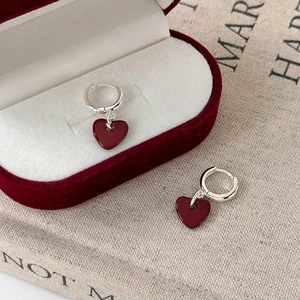 Elegant silver heart drop earrings with deep red enamel charms on a velvet box