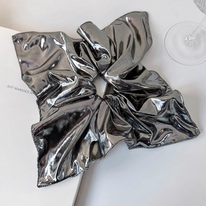 Detail of silver metallic scrunchie with pleated texture and reflective finish