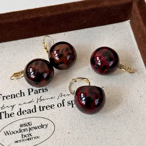 Vintage leopard print ball earrings with gold hooks in dark brown and burgundy colors