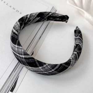 Detail of handmade plaid fabric headband featuring a black and white checkered pattern