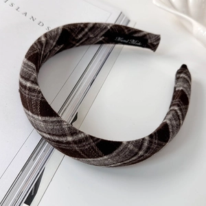Detailed macro view of retro plaid fabric headband with Hand Made label on inner side