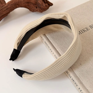 Detail view of cream-colored ribbed knit headband with anti-slip inner teeth on books