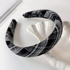 Macro view of black and white plaid thick headband with textured fabric detail