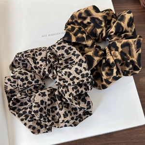 Leopard print scrunchie set in light and dark brown fabric on a vintage background