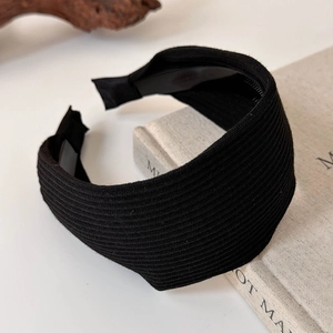 Close-up detail of black knitted ribbed headband showing texture and wide non-slip design
