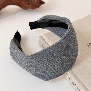Detail of dark grey knitted wide headband with vertical ribbed texture and soft fabric liner