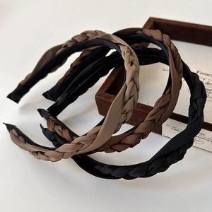Detailed view of woven satin twist headbands in various earth tones like brown and black