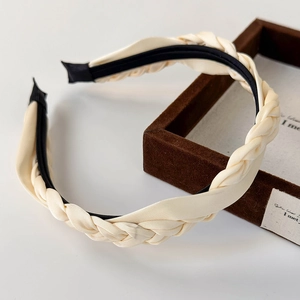 Detail of cream white satin braided headband showing smooth texture and woven craft