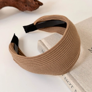 Macro detail of brown knitted wide headband texture and smooth inner black lining