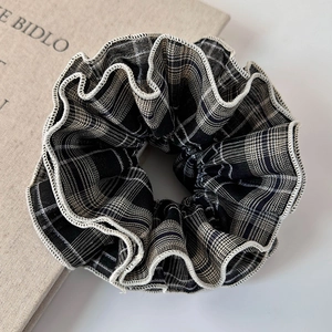 Detail view of large checkered scrunchie with layered lace edges and wavy fabric texture