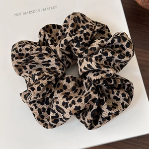 Close-up of leopard print chiffon scrunchie with soft fabric texture and elastic band
