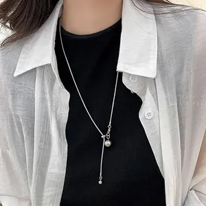 Gros plan d'un collier en Y argenté ajustable avec sphères métalliques sur un mannequin