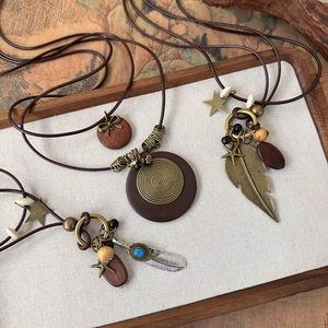 Ethnic style long beaded sweater necklace featuring wooden pendants and vintage feathers