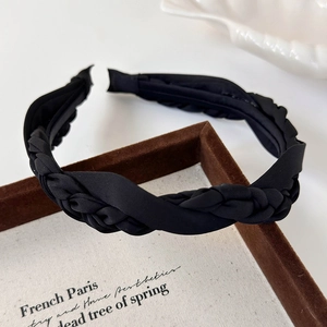 Detail of a French vintage black satin twisted headband on a rustic wooden tray
