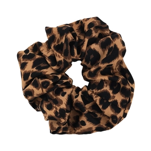 Close-up of large leopard print scrunchie with soft pleated texture and elastic band