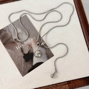 Détail d'un collier chaîne serpent argentée ajustable avec pendentif sphérique poli