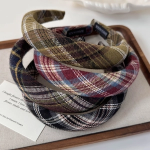 Detail of assorted vintage plaid headbands with handmade labels on wooden tray