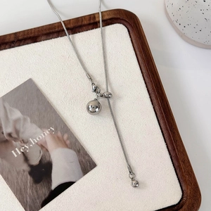 Vue détaillée du collier ajustable en argent avec pendentifs boules en métal poli