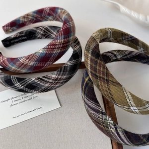 Detailed close-up of thick plaid headbands showing texture and handmade interior label