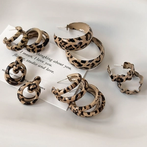 Detailed close-up of leopard print hoop earrings set with golden alloy finish and texture
