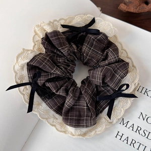 Detailed macro view of vintage brown plaid scrunchie with lace edge and ribbon bows