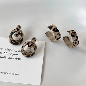 Detail showing two pairs of leopard print earrings with a double hoop and C-shape design
