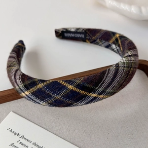 Close-up of handmade sponge plaid headband showing the retro fabric and inner label
