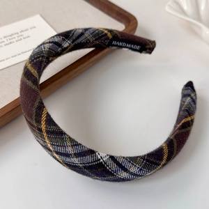 Detail of vintage plaid padded headband with handmade label and soft wool fabric texture