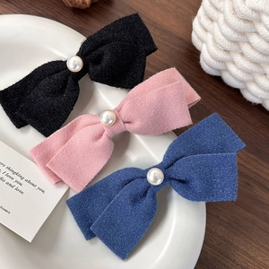 Detaillierte Makroansicht von schwarzen, rosa und blauen Perlen-Haarspangen auf Keramiktablett