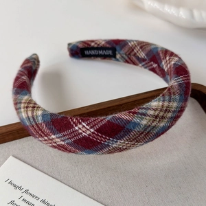 Detail of vintage plaid fabric headband with handmade woven label in a wooden tray
