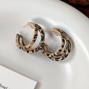 Detail view of triple-layered C-shaped leopard print earrings with vintage metal texture