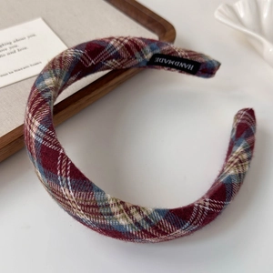 Detailed view of handmade plaid tartan headband with a woven texture and luxury label