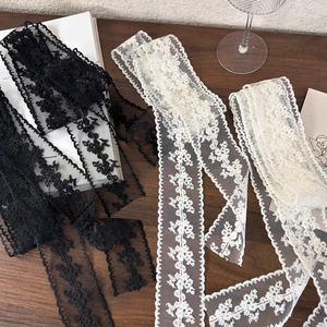 Detail of vintage lace ribbons in black and white showing delicate embroidery texture