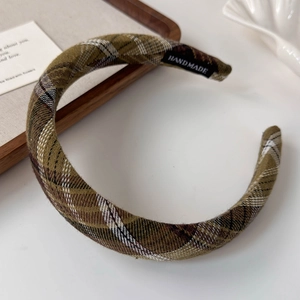 Detailed view of handmade vintage plaid headband with olive green wool fabric texture