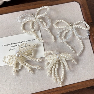 Détail de charmes de chaussures en forme de nœuds de perles et cristaux sur plateau en bois