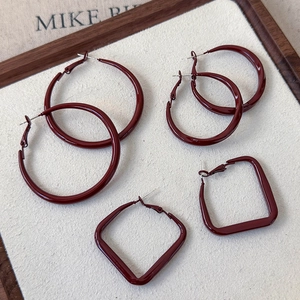 Detailed macro view of deep red geometric hoop earrings with polished glossy finish