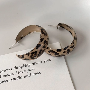 Detail shot of vintage leopard print C-shape hoop earrings on a white display card