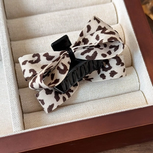 Détail macro d'une pince à cheveux chic à motif léopard sur un plateau à bijoux en velours
