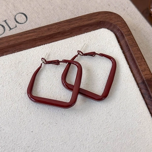Detail view of retro square matte burgundy enamel geometric hoop earrings on wood