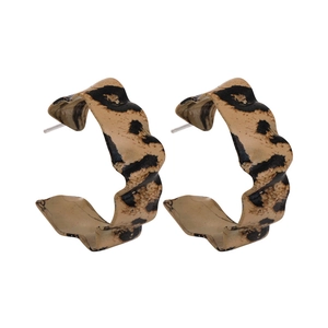 Detailed view of C-shaped earrings with leopard print pattern and metallic ear posts