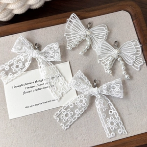 Détail de nœuds en dentelle blanche avec perles et glands pour décoration de chaussures