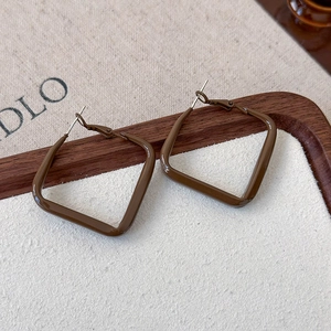 Detail of square dark coffee metal earrings with a retro French glossy finish