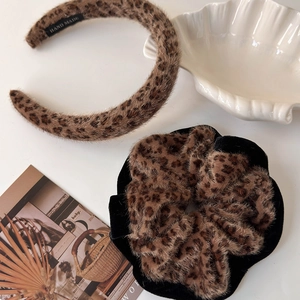 Detail view of plush leopard print headband and scrunchie set with soft faux fur texture