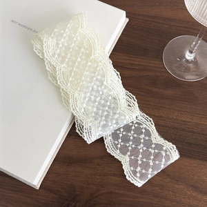 Detailed macro shot of elegant off-white lace ribbon with floral embroidery patterns
