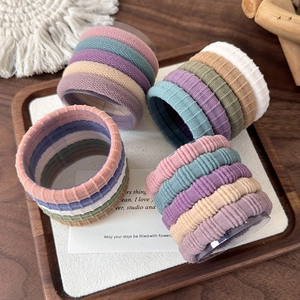Detail van naadloze elastische haarelastiekjes met geribbelde textuur in macaronkleuren