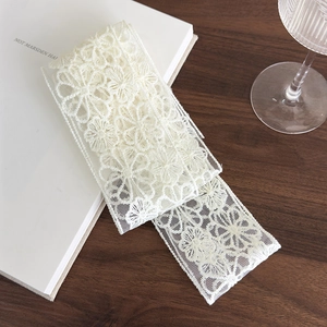 Detail of vintage beige lace ribbon showing intricate floral embroidery on soft mesh fabric