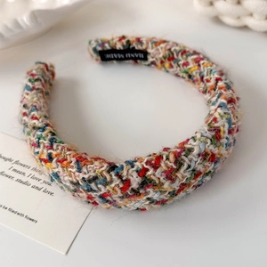 Nahaufnahme eines bunten handgestrickten Haarreifens mit Textur und Hand Made Etikett
