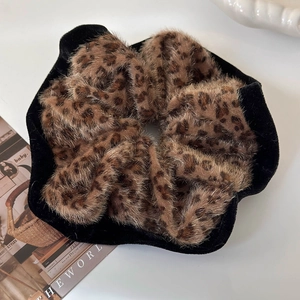 Detail of leopard print faux fur and black velvet trim on a plush scrunchie accessory