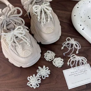 Elegant crystal pearl bow shoe clips on beige sneakers for stylish footwear decoration