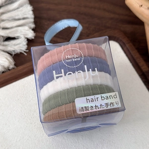 Detail van vijf naadloze haarelastiekjes in pastelkleuren en geribbelde gebreide textuur